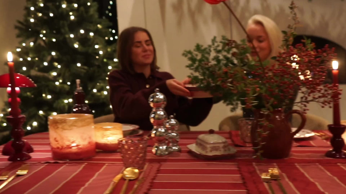 Gedekte kersttafel met vriendinnen bij kaarslicht